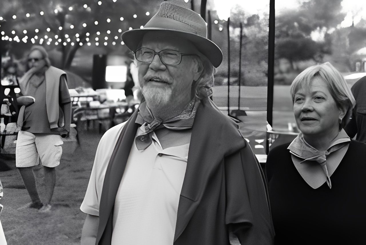 Man and woman at outdoor event, smiling.