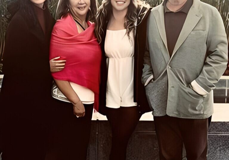 Group of four people smiling together.