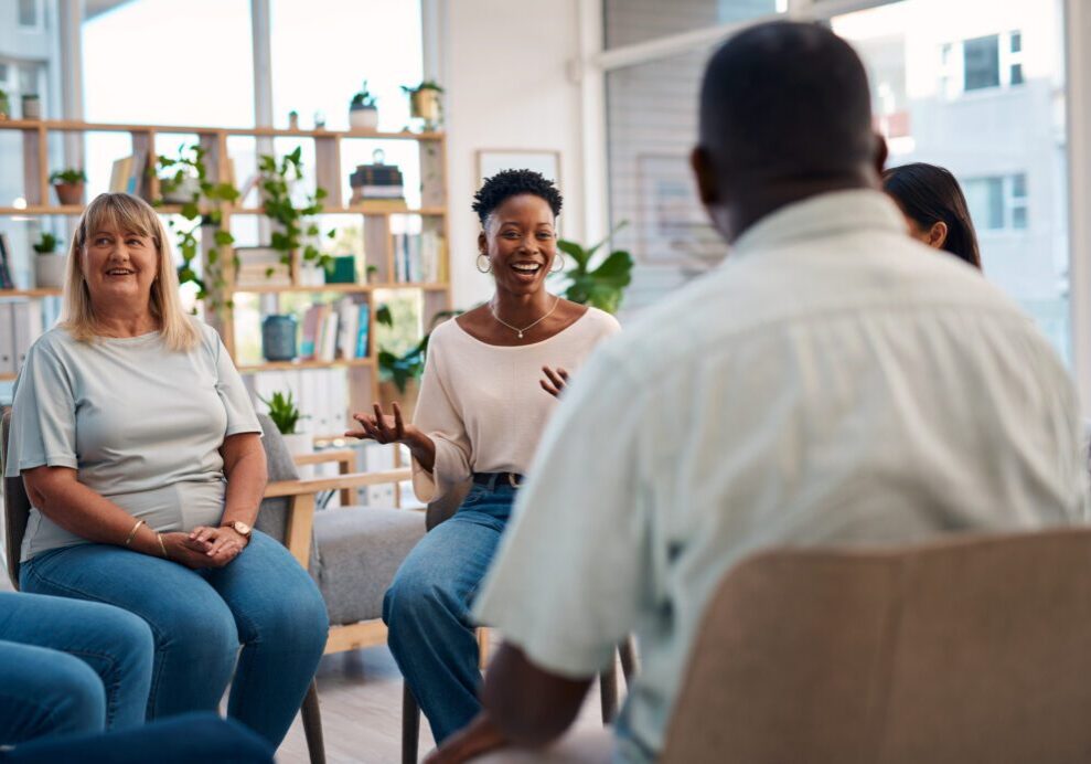 Group therapy session with people sharing experiences.