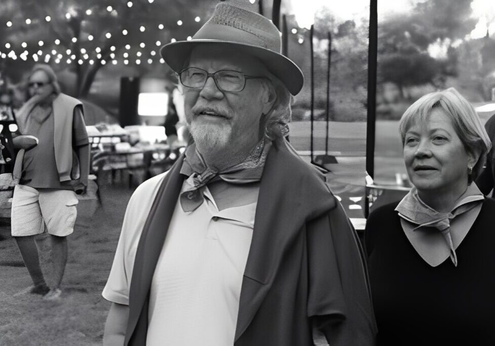 Man and woman at outdoor event, smiling.